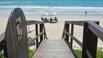 On the beach, white sand, sun loungers, beach umbrellas