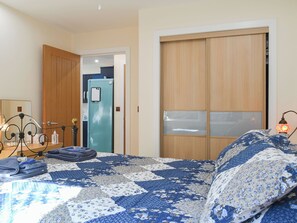 A bedroom with a bed, a wardrobe, a mirror, and a nightstand. - 2 bedroom accommodation in Connel, near Oban (Connel, near Oban)