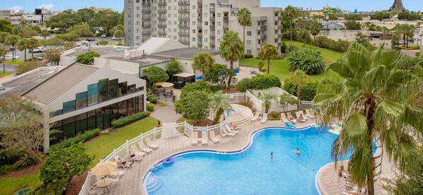 A hotel with a swimming pool surrounded by palm trees and lounge chairs. - Superb Renovated Suite, Amazing Water View Best Location to Disney and Universal (Orlando)