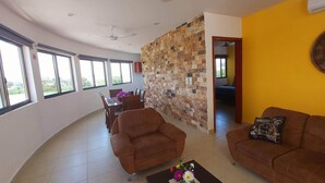 A spacious living area with a dining table, two sofas, and a decorative wall. - Suite isla Mujeres (Isla Mujeres)