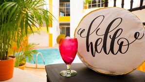 A cocktail glass with a lemon slice on a table next to a 'hello' pillow. - Suite isla Mujeres (Isla Mujeres)