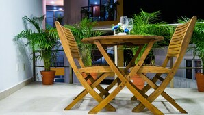 A wooden table and chairs set outdoors with potted plants around. - Suite isla Mujeres (Isla Mujeres)