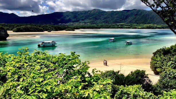A coastal landscape with clear turquoise waters, boats, and lush greenery. - Panoramic Ocean View - downtown/ high speed WiF (Ishigaki)