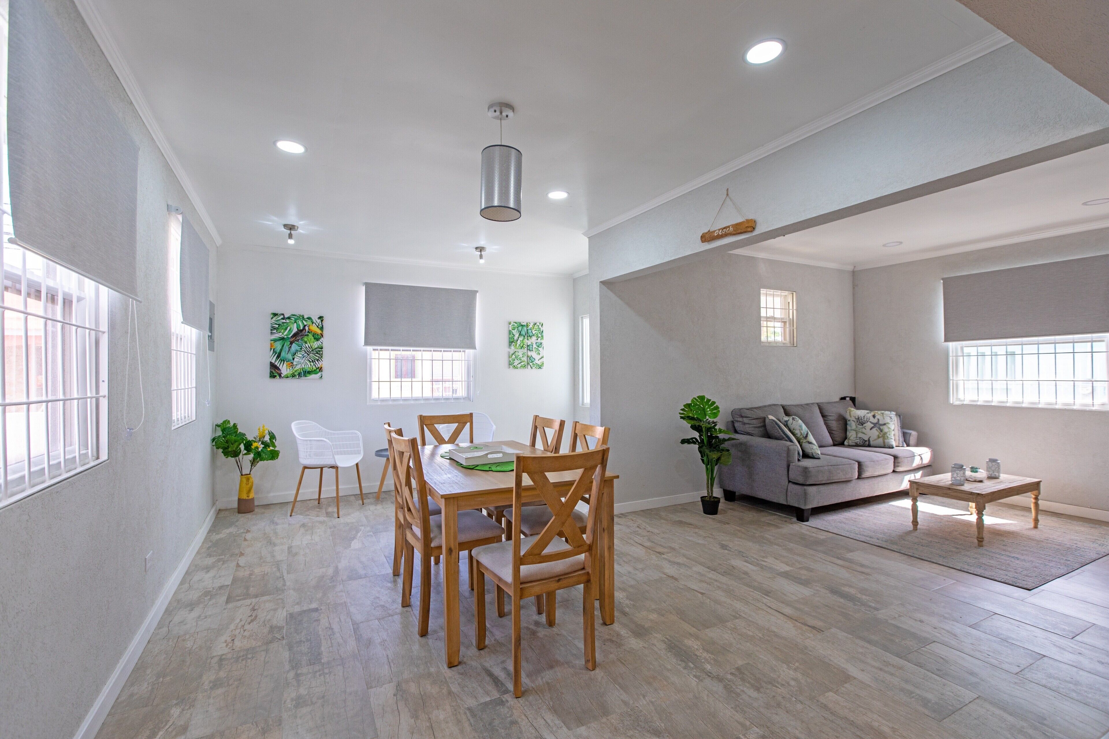 A spacious living area with a dining table, chairs, a sofa, and a coffee table.
