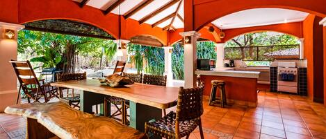 A spacious kitchen with a large island, bar stools, and a dining table.