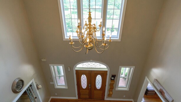 A grand entryway with a chandelier, wooden doors with stained glass, and a view of the outdoors. - Ridge Creek Getaway, ideal 4 Friends&Family get-togethers, events & receptions.  (Brentwood)