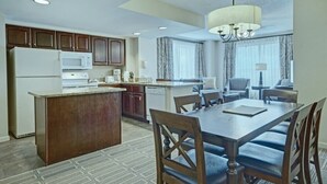 A hotel room with a dining area, kitchenette, and a large window with curtains. - Alexandria | Couples Capital Stay | Gym + WiFi (Alexandria)