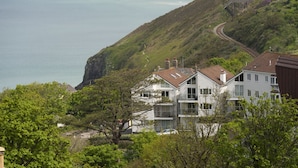Zona residencial costera con casas, una vía ferroviaria y una playa.