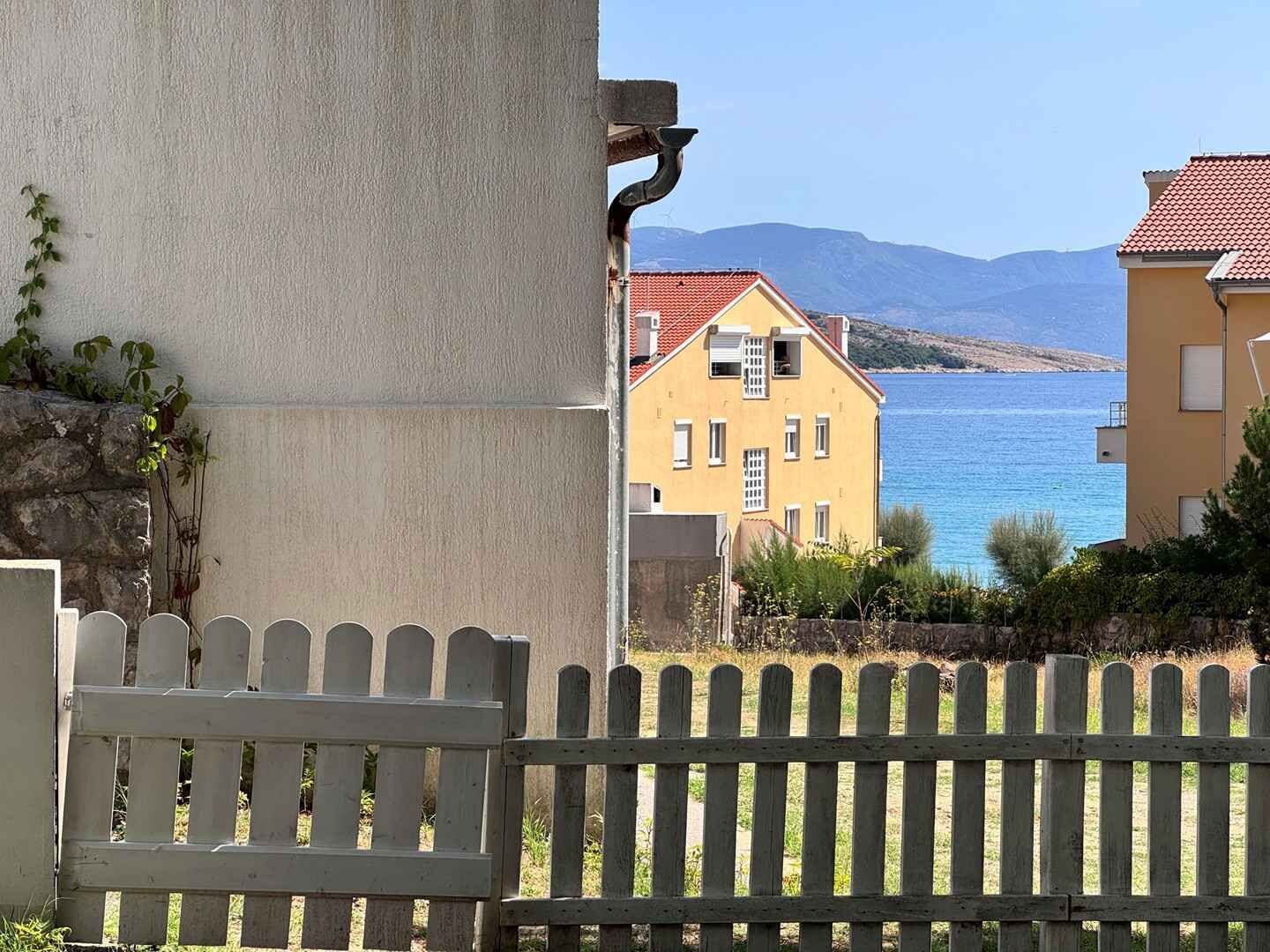 Un edifici a la costa amb vista al mar i a les muntanyes.