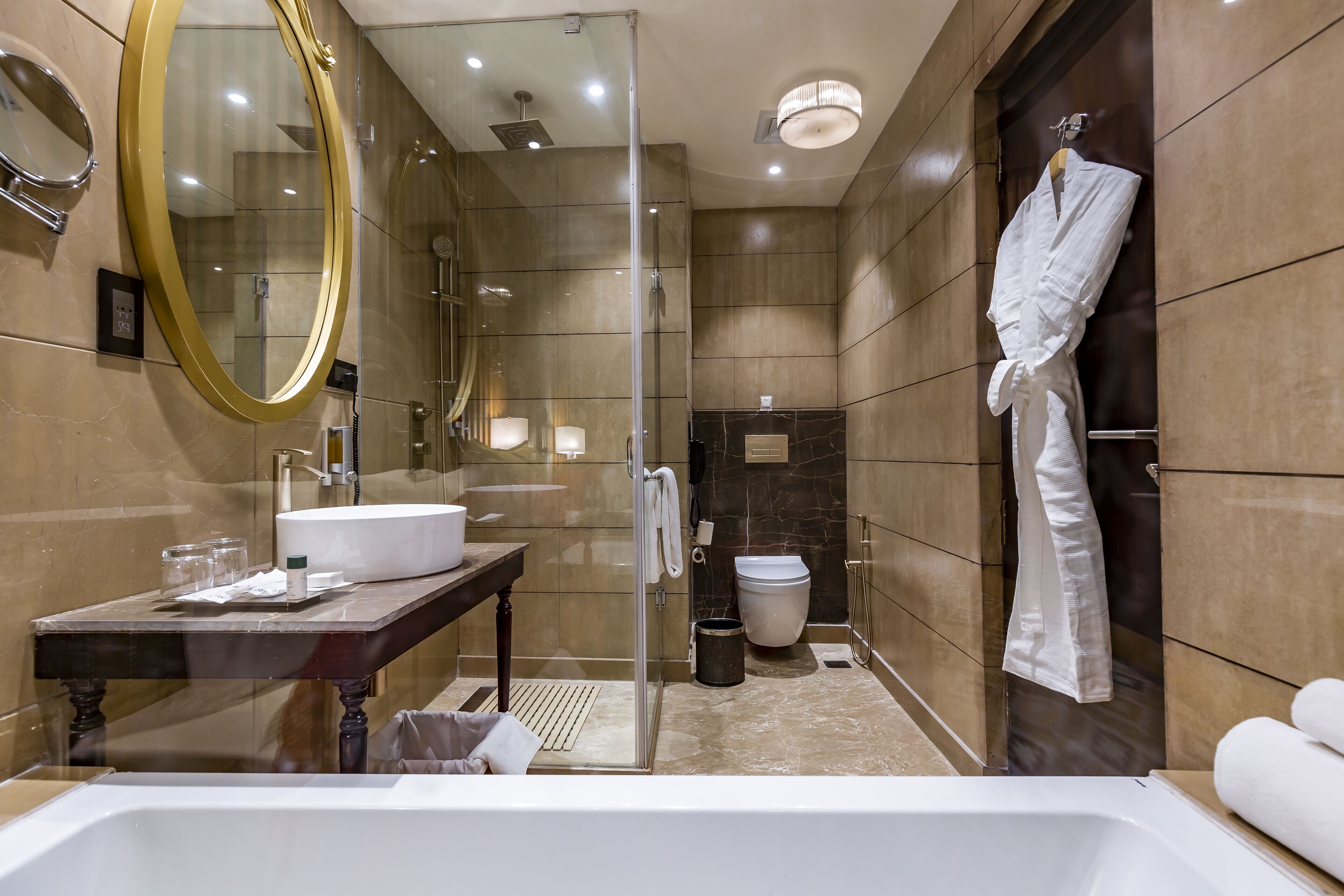 A modern bathroom with a glass-enclosed shower, a large mirror, a sink, and a bathtub.