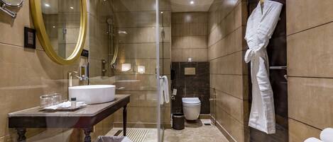 A modern bathroom with a glass-enclosed shower, a large mirror, a sink, and a bathtub.