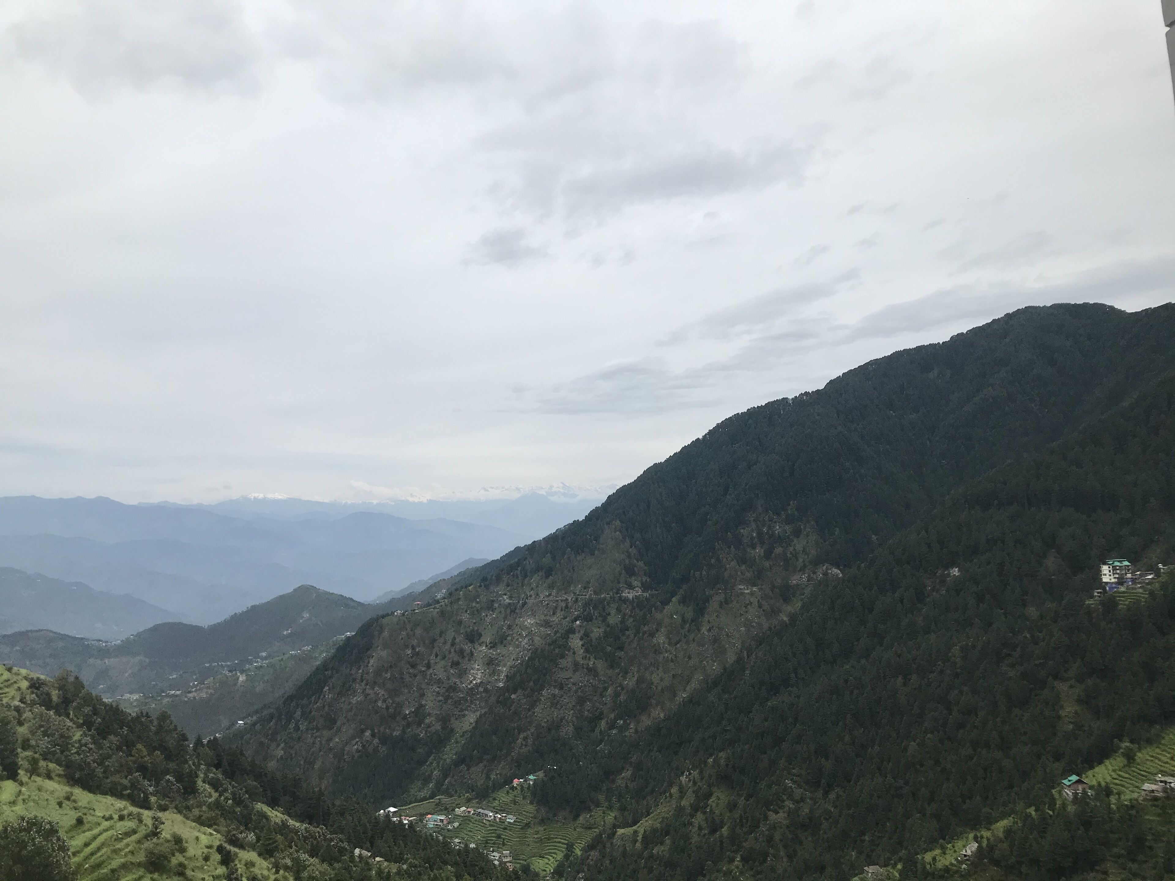 Paisaje montañoso con campos en terrazas y edificios dispersos.