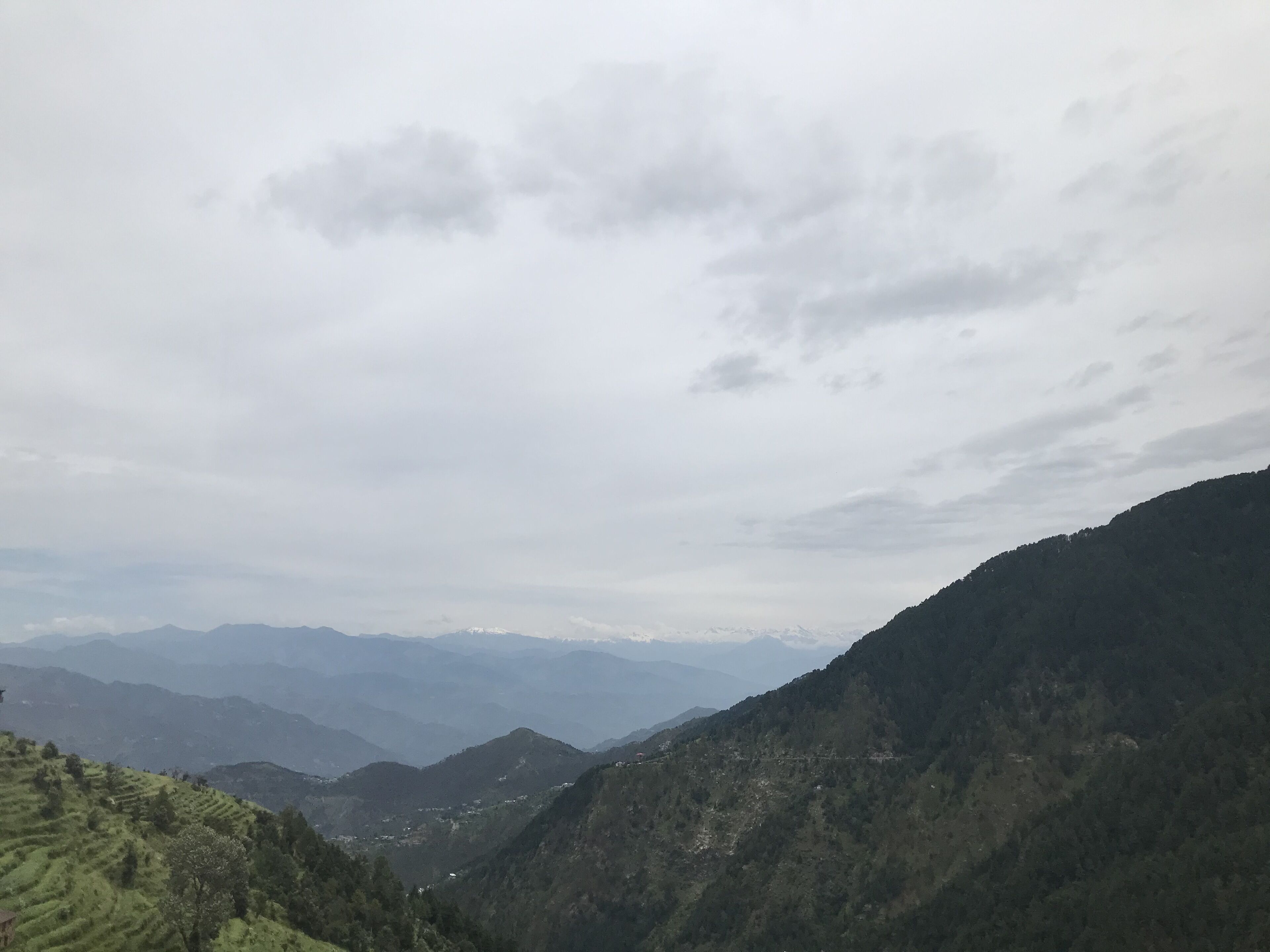 Un paysage montagneux avec des champs en terrasses et une vallée.