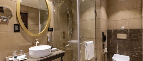 Un baño moderno con un espejo ovalado grande, un espejo redondo, un lavamanos, un inodoro y una zona de ducha.