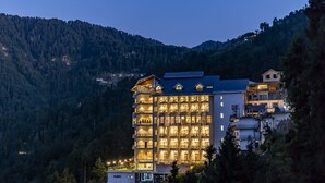 Un hotel de varios pisos con balcones, situado en una zona montañosa.