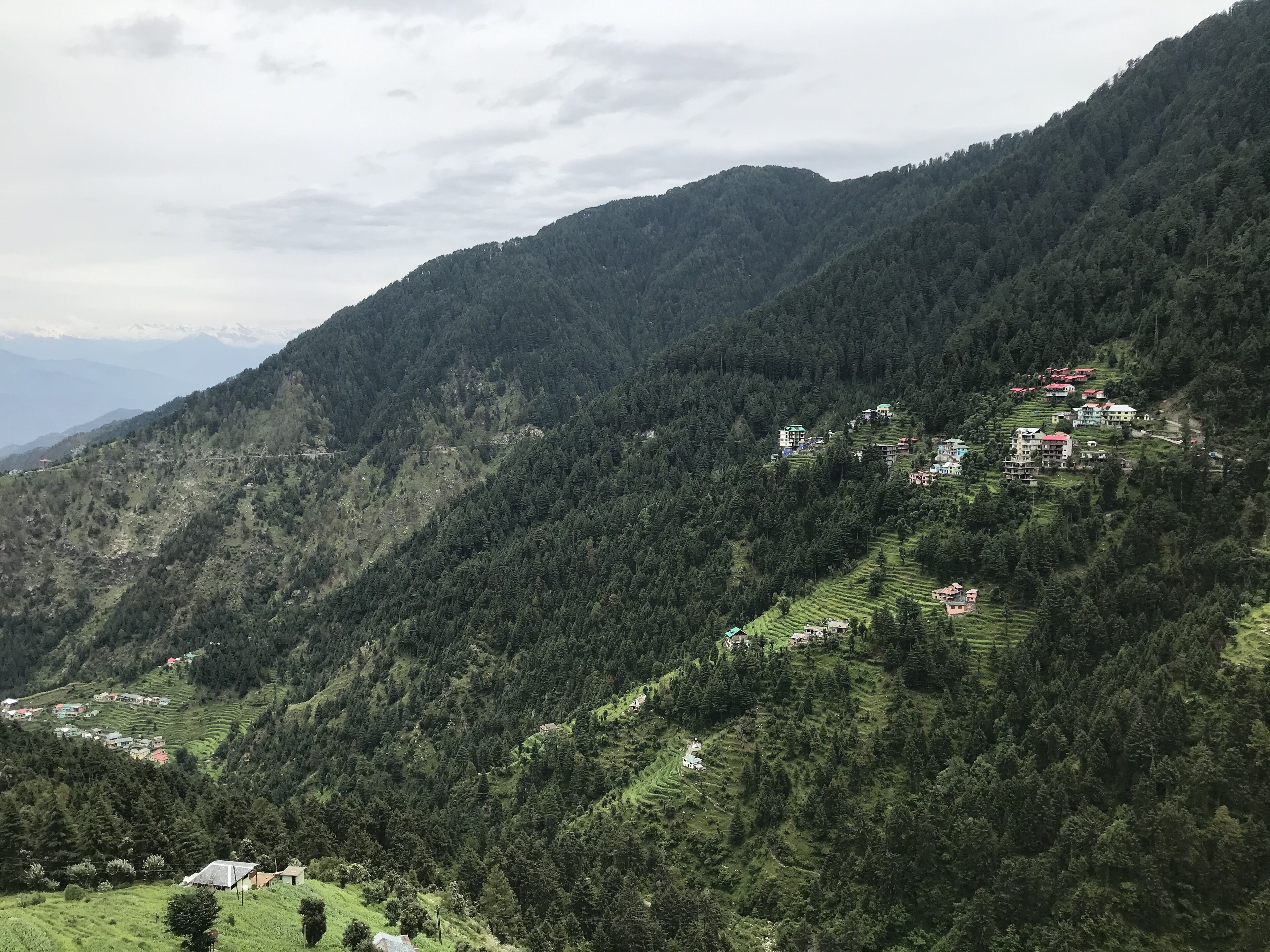 A mountainous landscape with terraced fields and scattered buildings.