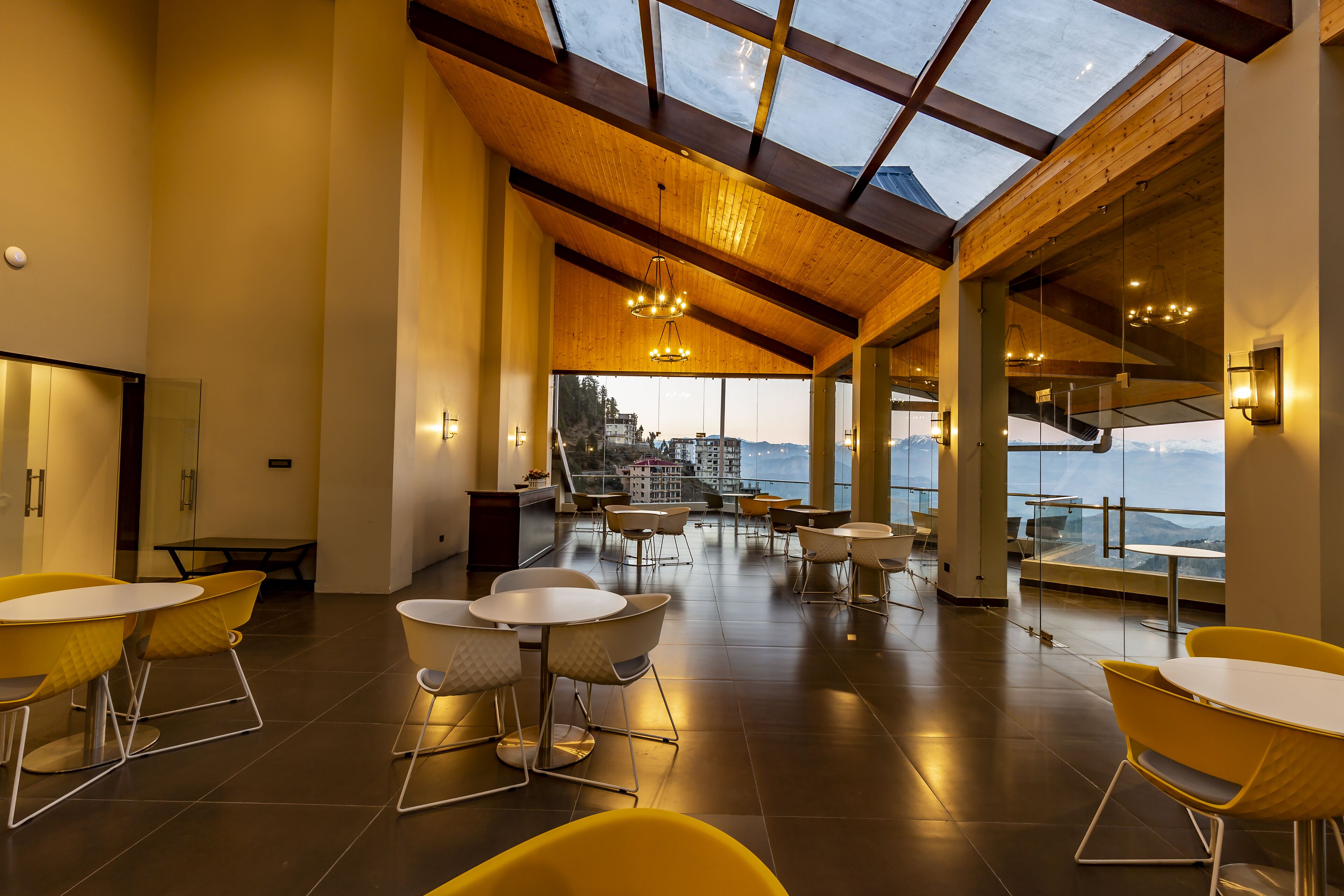 Un espacio interior amplio con techo alto, ventanas grandes y mobiliario moderno.