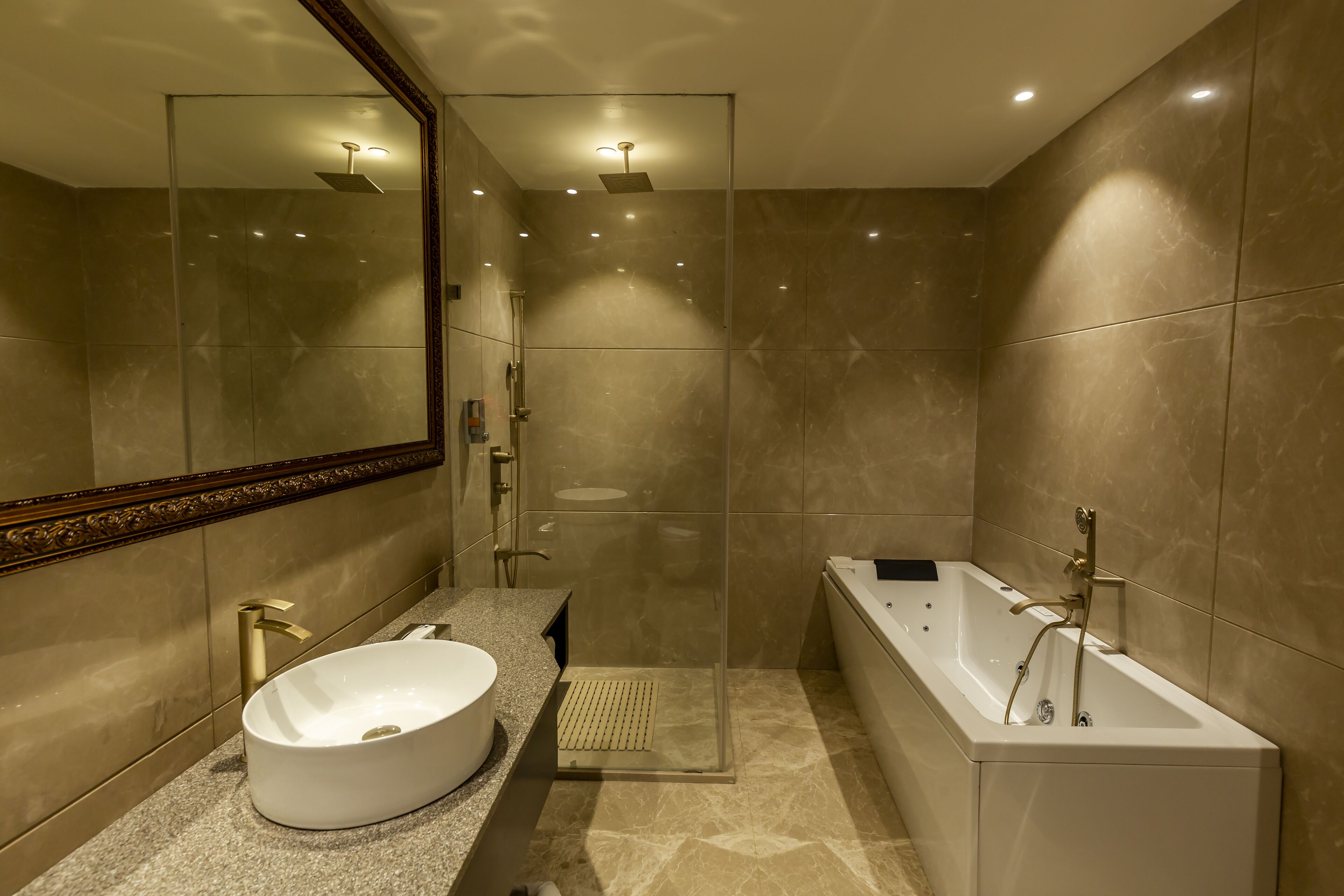 Een moderne badkamer met een grote spiegel, een vrijstaand bad en een douche met glazen wanden.