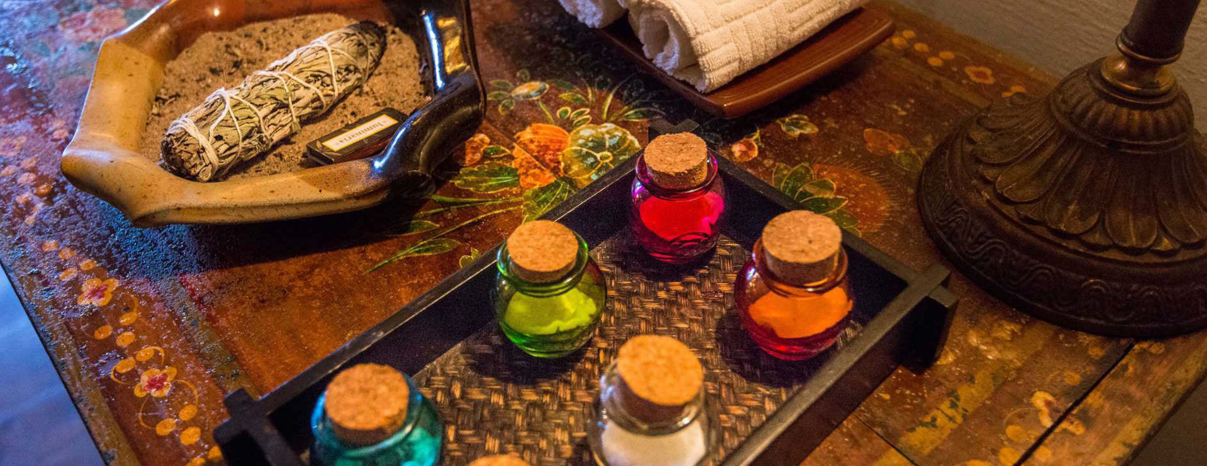 A tray with various items including a rolled object, a small bottle, and several bottles with corks.