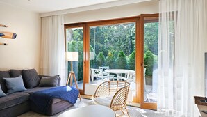 Een moderne woonkamer met een bank, een salontafel en een eethoek met stoelen.