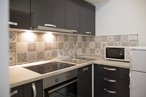 A modern kitchen with a built-in microwave, a sink, and a dishwasher.