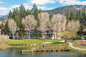A lakeside hotel with multiple buildings, a dock, and a walking path.