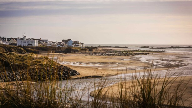 A coastal landscape with buildings and a beach.