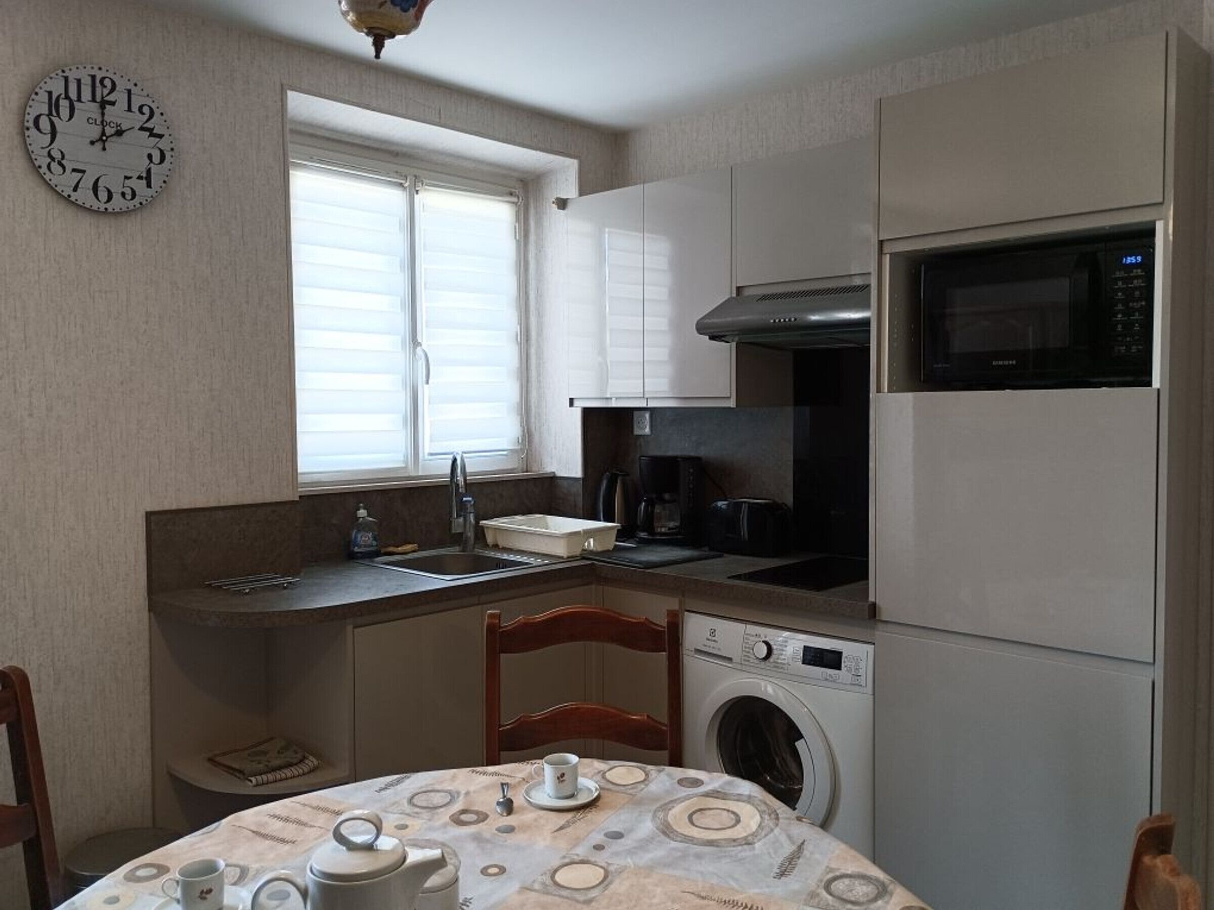 A compact kitchen with a sink, microwave, and washing machine.