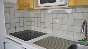 Een keuken met een magnetron, spoelbak en vaatwasser.