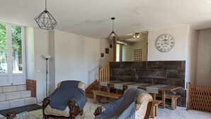 Un salon avec deux fauteuils en bois, une table basse en verre et une cheminée.
