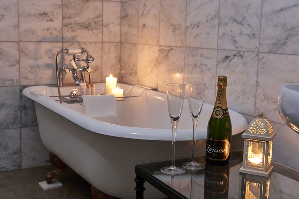 Cast iron roll top bath and marble tiled bathroom