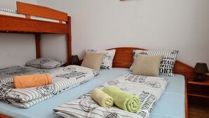 A double bed with striped bedding, a wooden headboard, and two bedside tables with lamps.