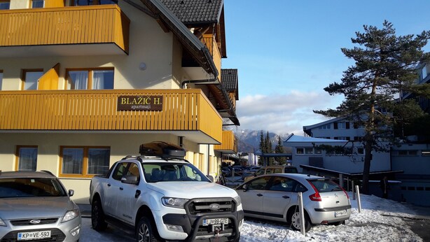 A multi-story building with a sign reading "BLAŽIČ H. apartmaji".