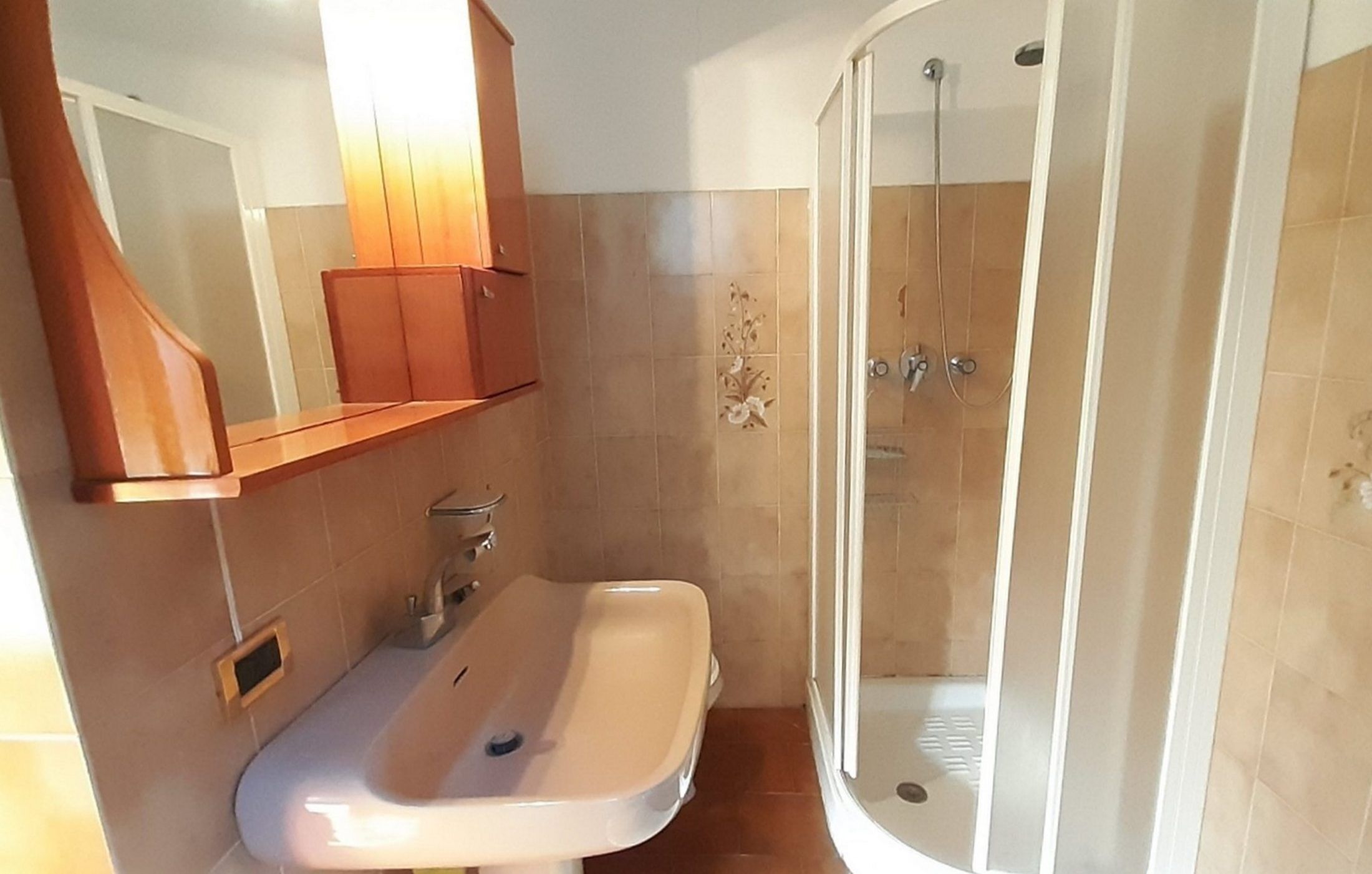 Ein Badezimmer mit Waschbecken, Spiegel und Dusche.