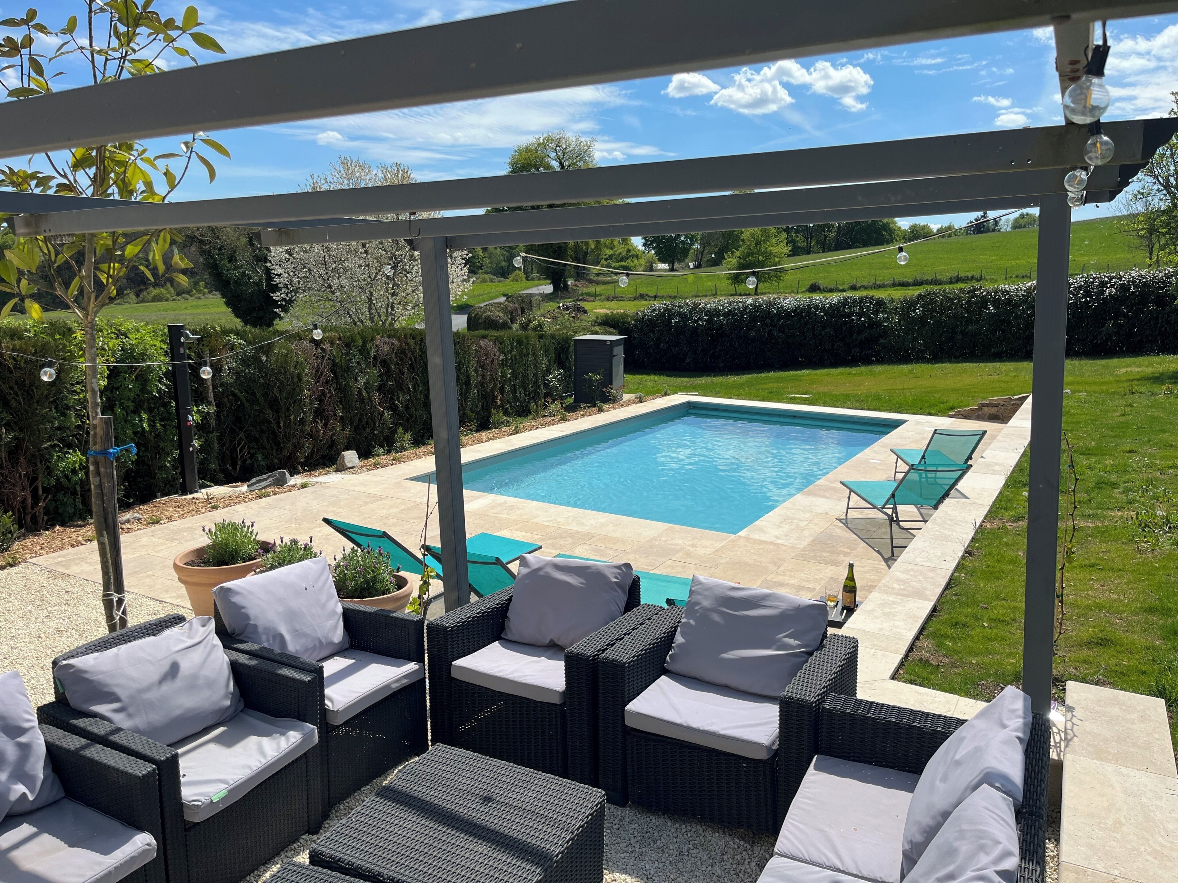 An outdoor pool area with lounge chairs and a pergola.