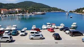 Un port de plaisance avec des bateaux amarrés et des voitures garées sur un parking.