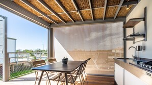 Une cuisine moderne dotée d’une grande fenêtre, d’un plancher en bois et d’un coin repas avec une table et des chaises.