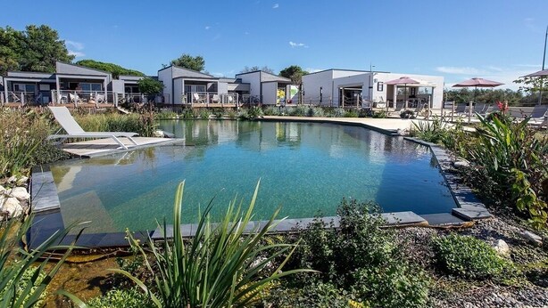 Un hôtel moderne doté d’une piscine, d’un espace extérieur aménagé et d’un jardin bien entretenu.