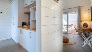 Une cuisine moderne avec des meubles blancs, des plans de travail en bois et un coin repas comprenant une table et des chaises.
