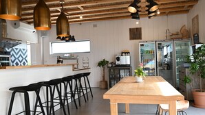 Une cuisine moderne avec une table en bois, des tabourets de bar noirs et des luminaires suspendus.