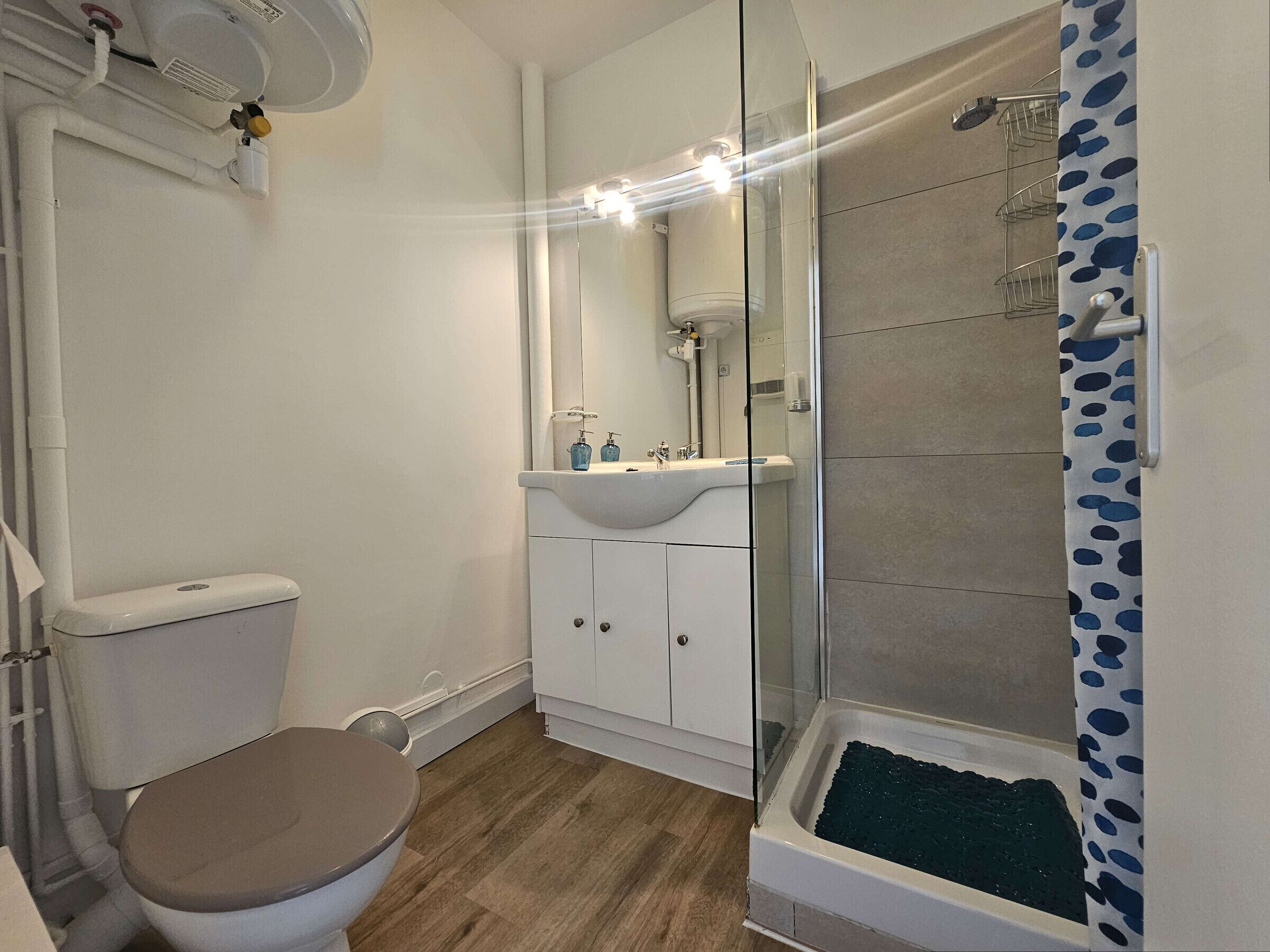 A bathroom with a toilet, sink, and shower.