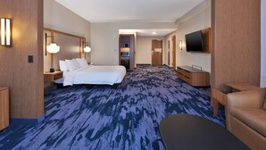 A hotel room with a large bed, a desk, a chair, a TV mounted on the wall, and a carpeted floor. -  Fairfield by Marriott Inn & Suites Knoxville Airport Alcoa (Alcoa)