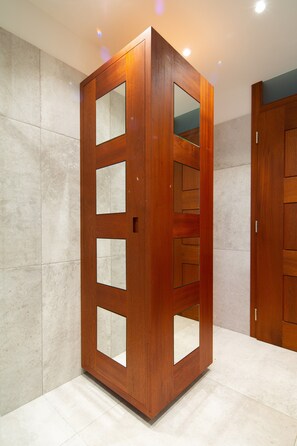 Un armadio in legno con ante a specchio e scomparti multipli.