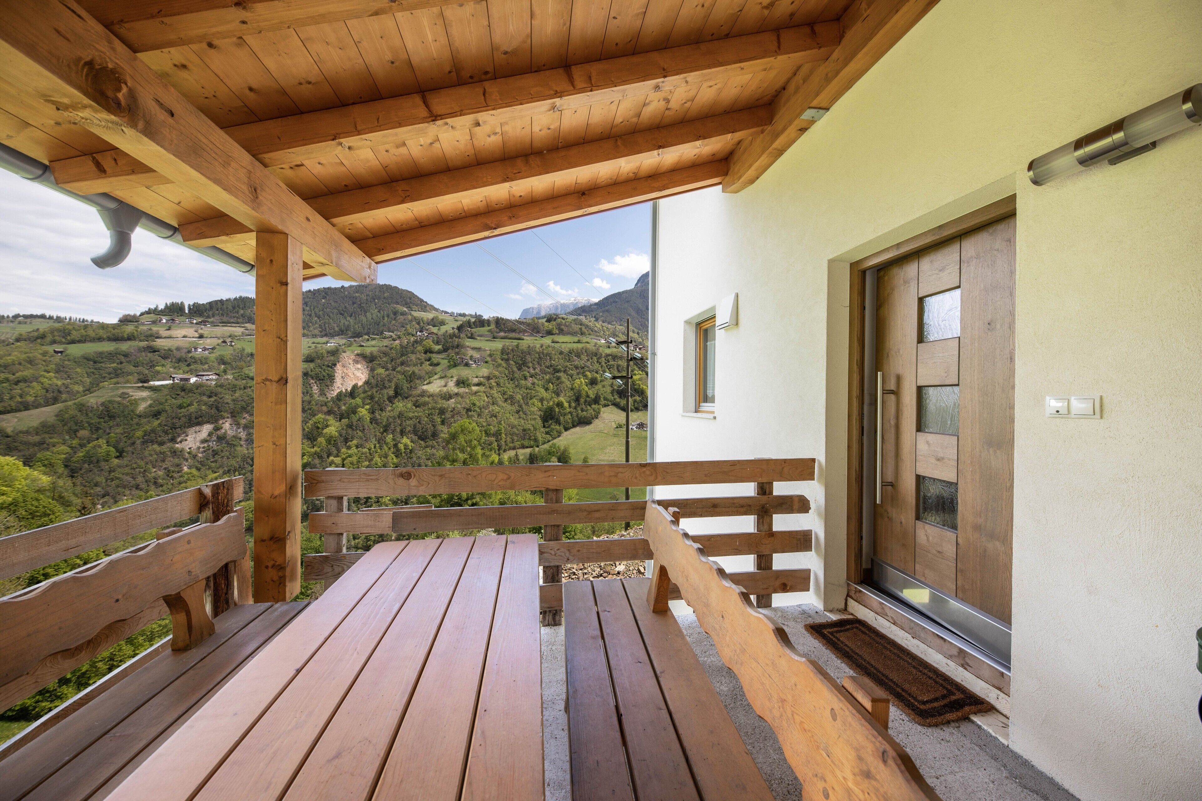 A wooden deck with benches overlooking a mountainous landscape.