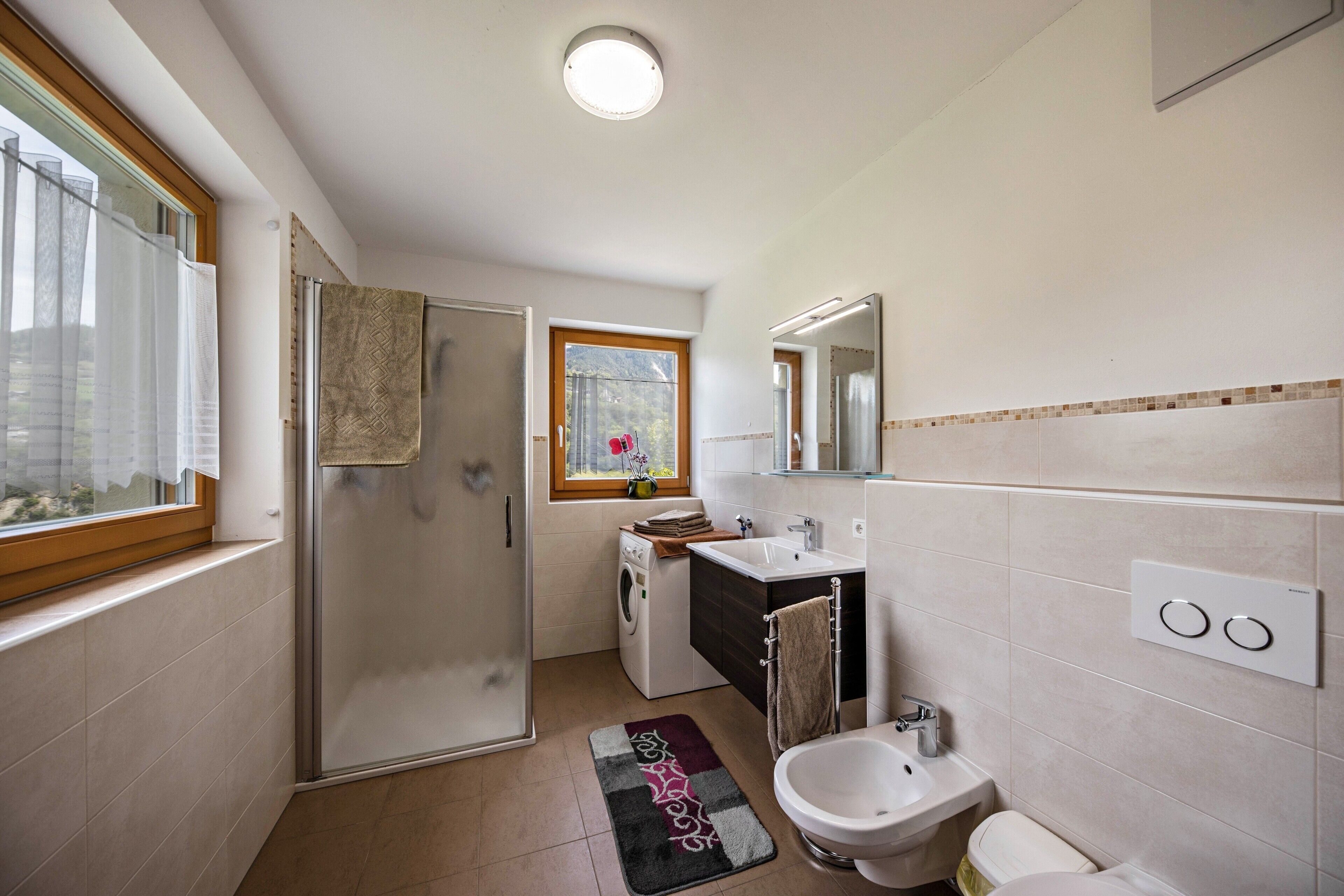 Un baño moderno con ducha, inodoro, bidé y lavamanos.