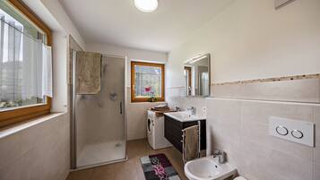 Un baño moderno con ducha, inodoro, bidé y lavamanos.