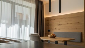 Un comedor moderno con una mesa de madera, un frutero y una banca.