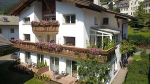 Une maison à deux étages dotée d’un balcon, d’une terrasse couverte et offrant une vue sur le paysage environnant.