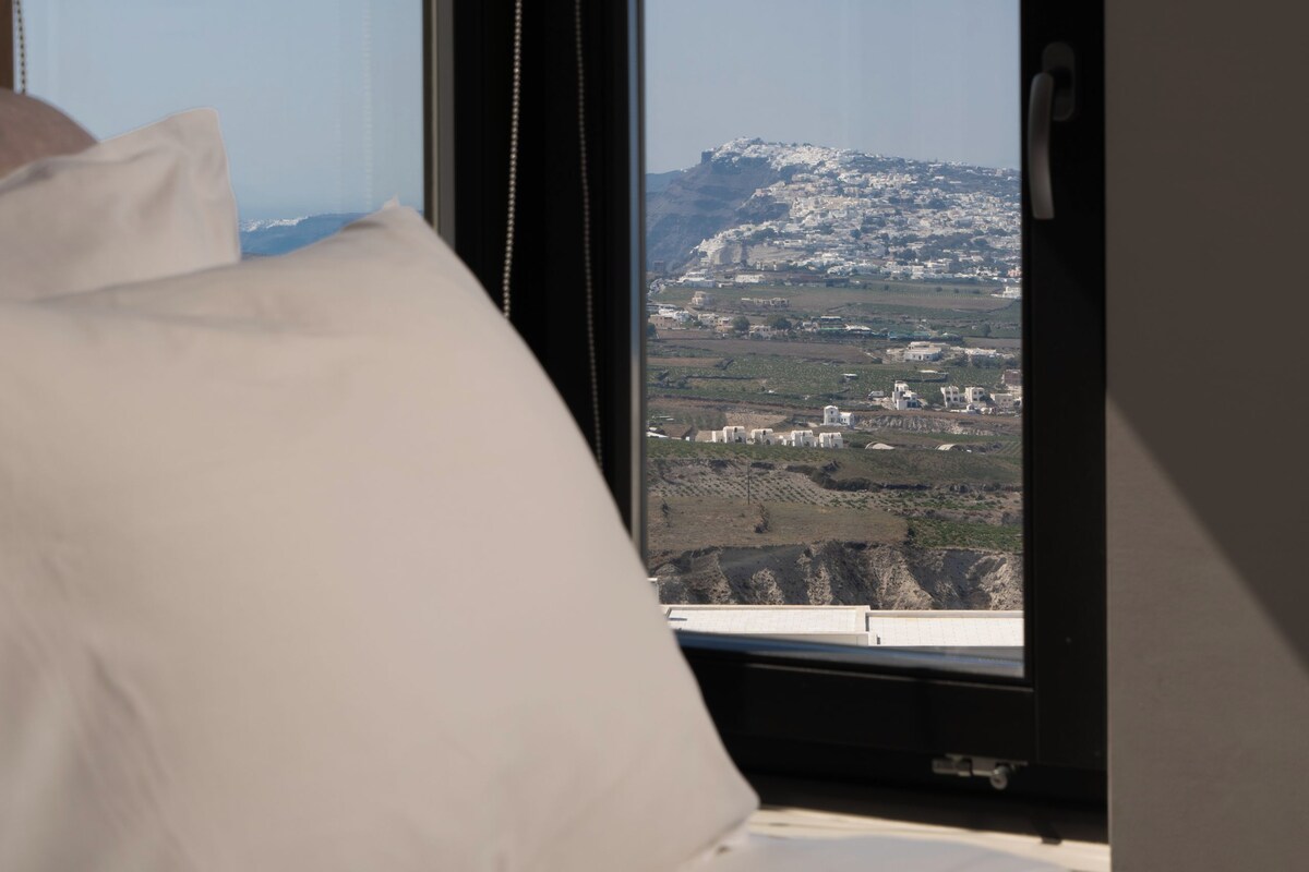 Un dormitorio con un ventanal que ofrece vistas a un paisaje montañoso.