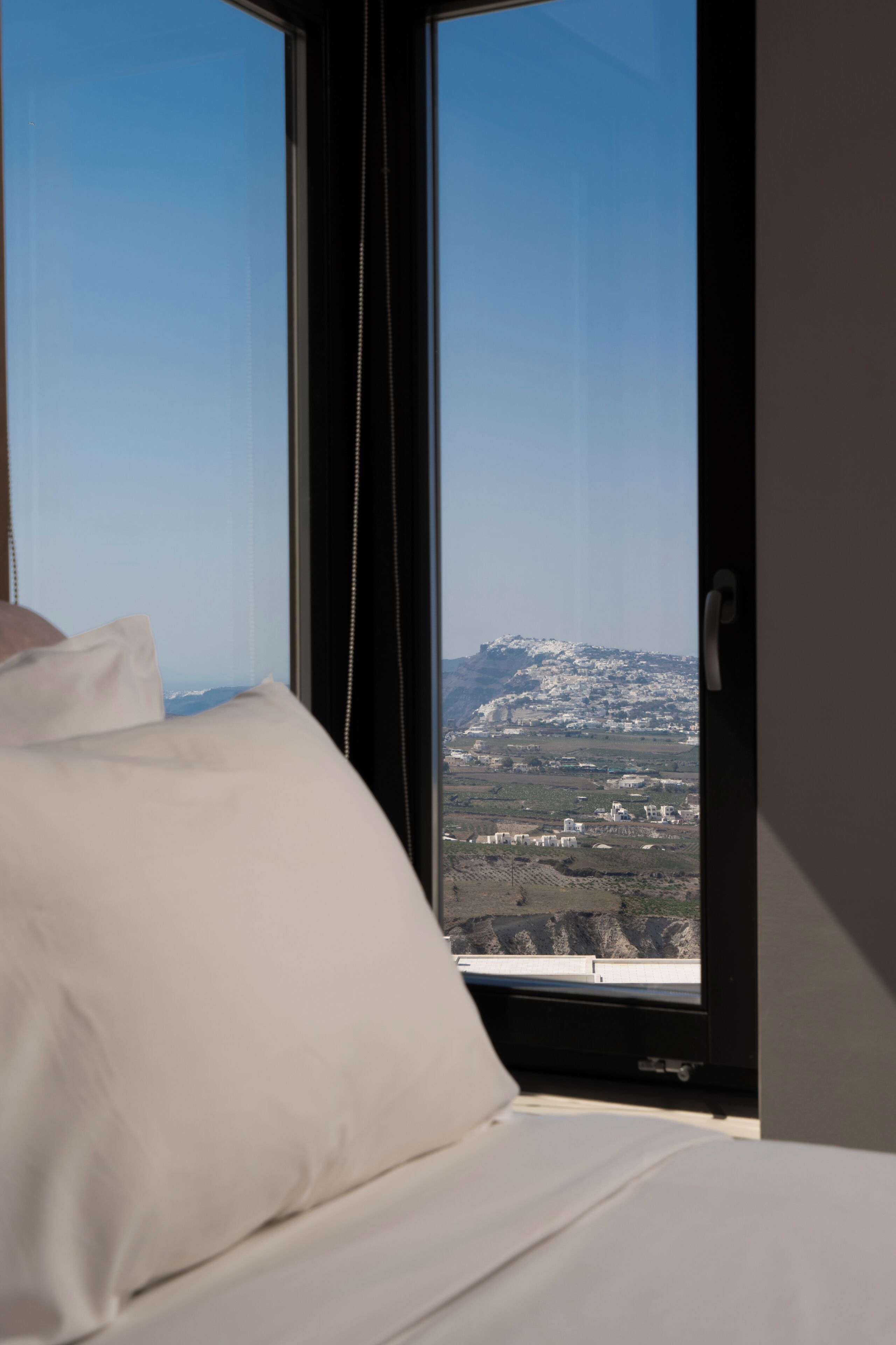 Une chambre à coucher dotée d’une grande fenêtre donnant sur un paysage montagneux.